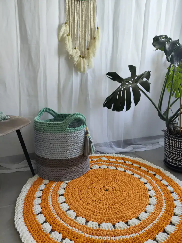 שטיח עגול בצבע כתום עם עיטורים לבנים