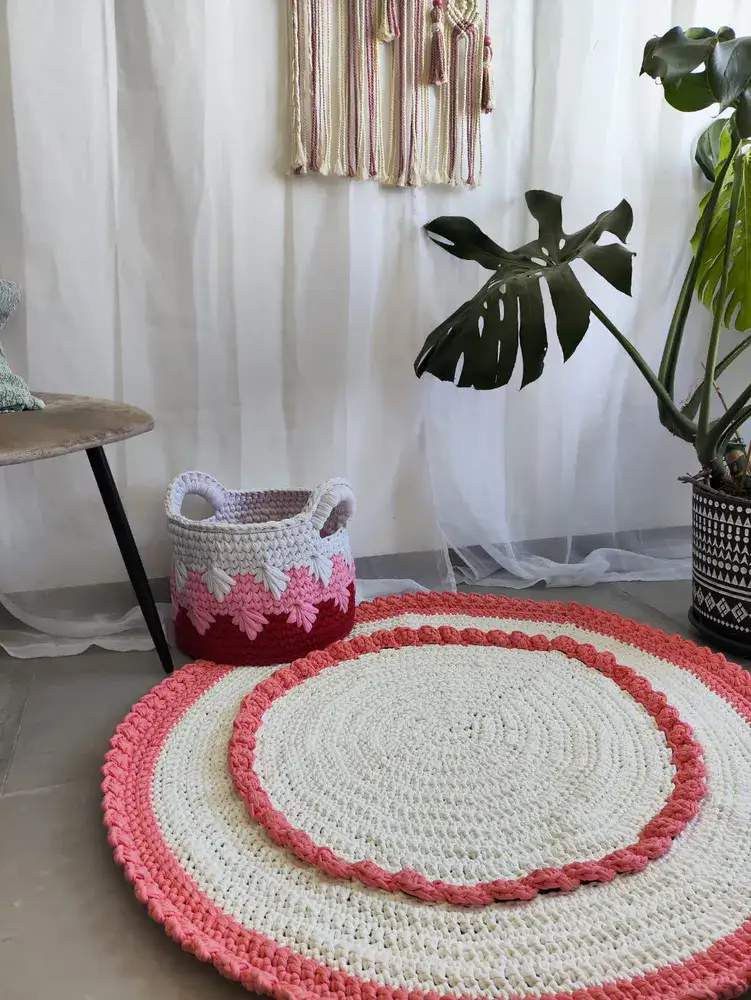 שטיח עגול בצבע לבן עם עיטורים ורודים