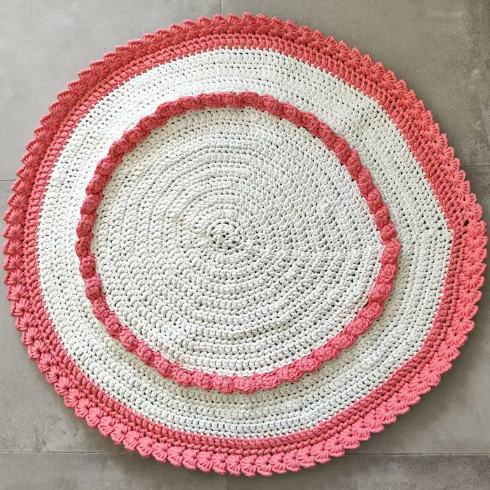 שטיח עגול בצבע לבן עם עיטורים ורודים