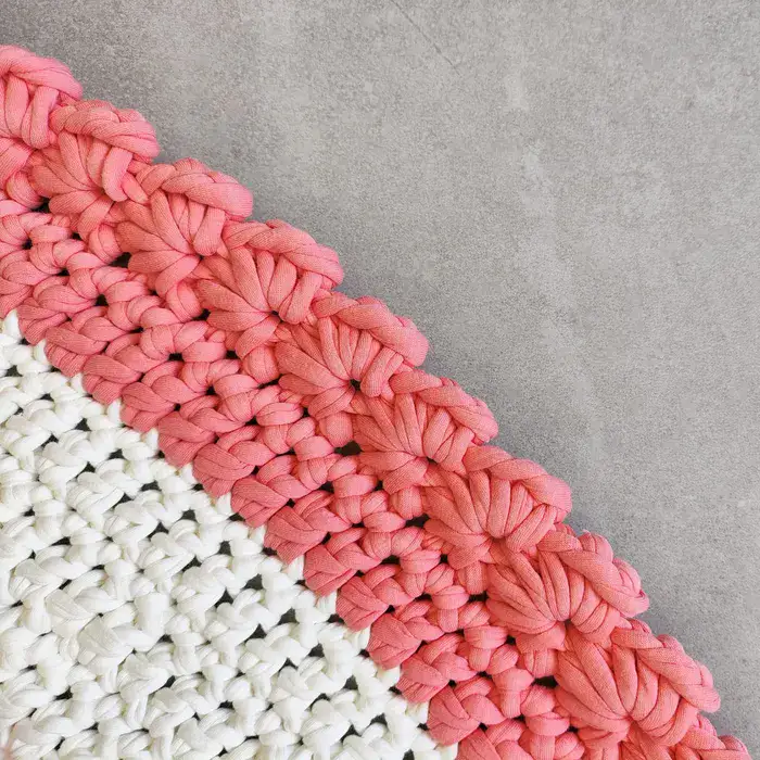 שטיח עגול בצבע לבן עם עיטורים ורודים