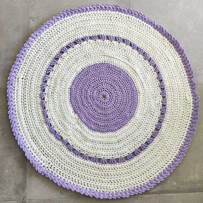 שטיח עגול בצבע לבן עם עיטורים סגולים