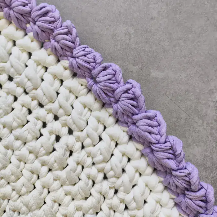 שטיח עגול בצבע לבן עם עיטורים סגולים