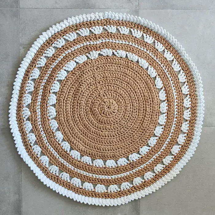 שטיח עגול בצבע בז' עם עיטורים לבנים