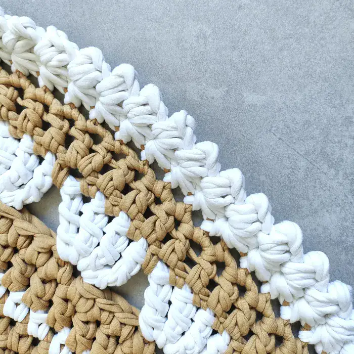 שטיח עגול בצבע בז' עם עיטורים לבנים