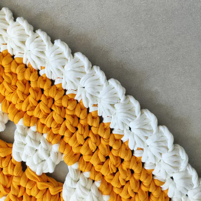 שטיח עגול בצבע כתום עם עיטורים לבנים