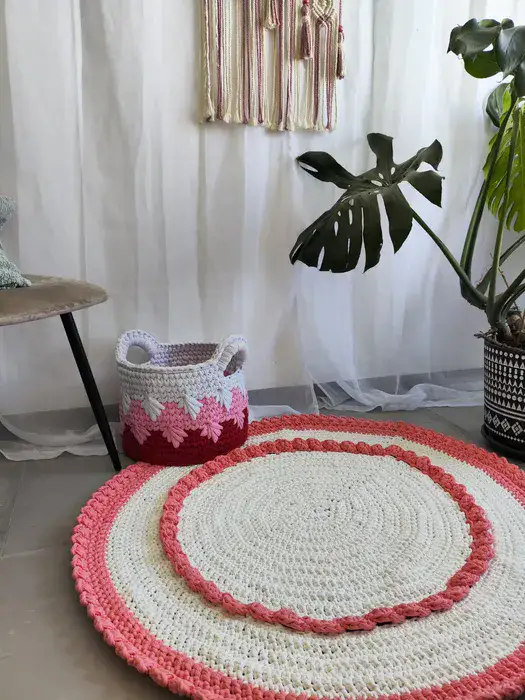 שטיח עגול בצבע לבן עם עיטורים ורודים